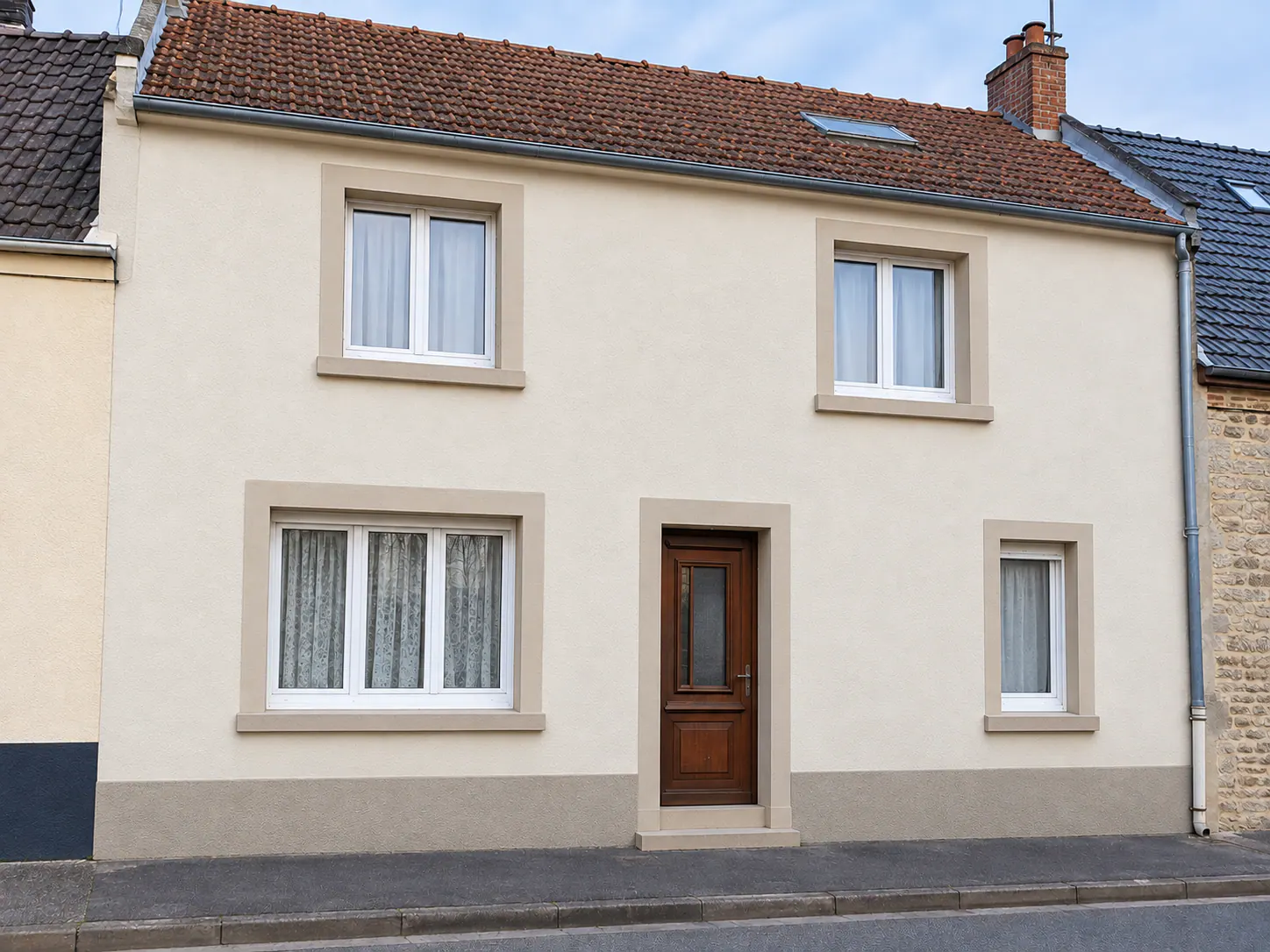 Ravalement de façade d'une maison à Isques, enduit crème avec soubassement gris et menuiseries blanches